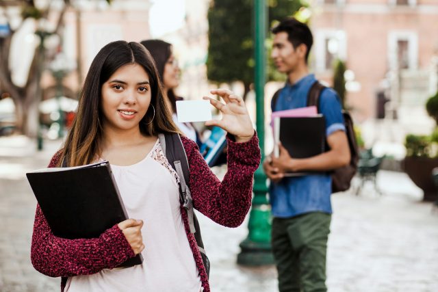 latin Female student or international student in internship holding an ID card in Mexico City